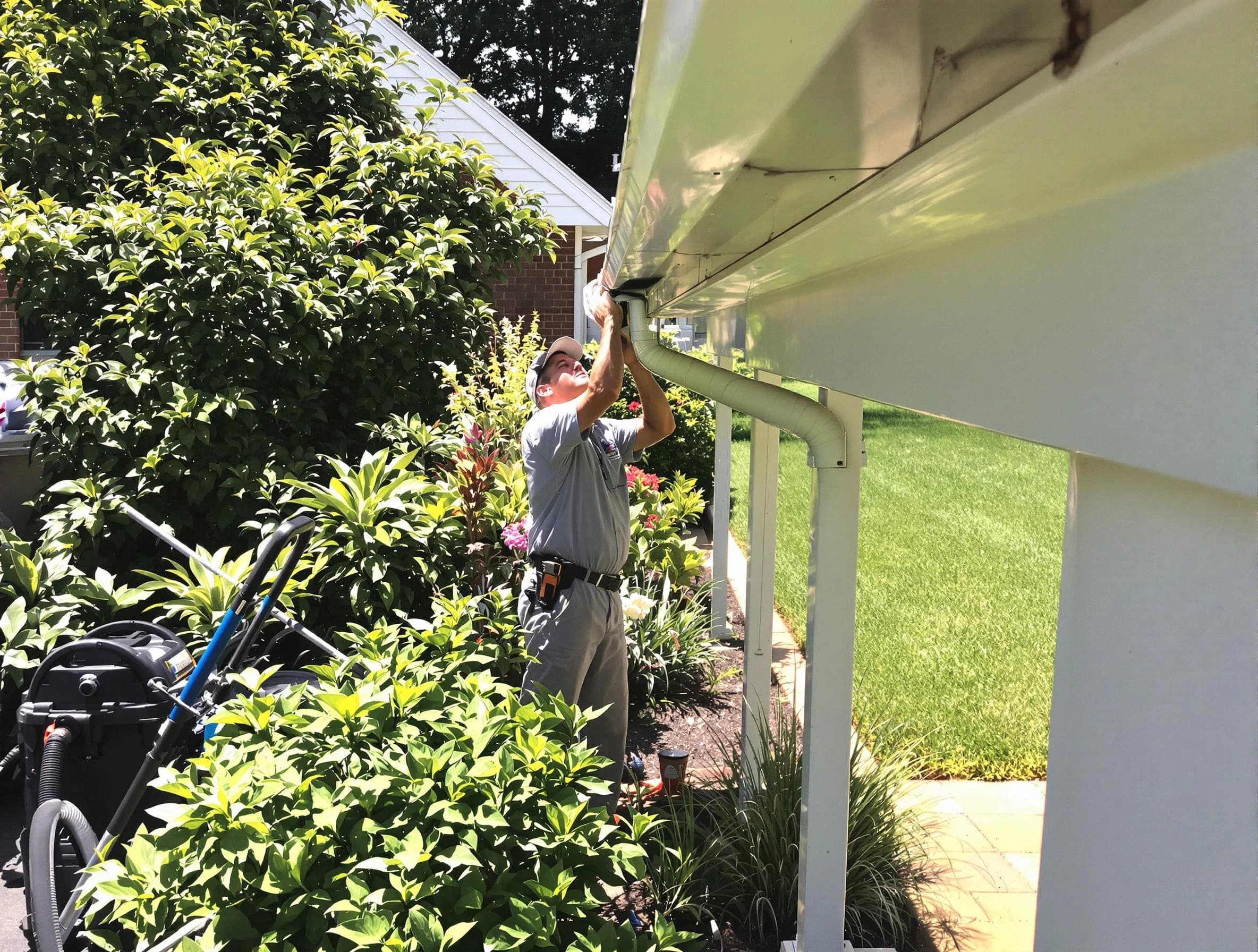 Technician flushing a blockage from a downspout in North Ridgeville, OH